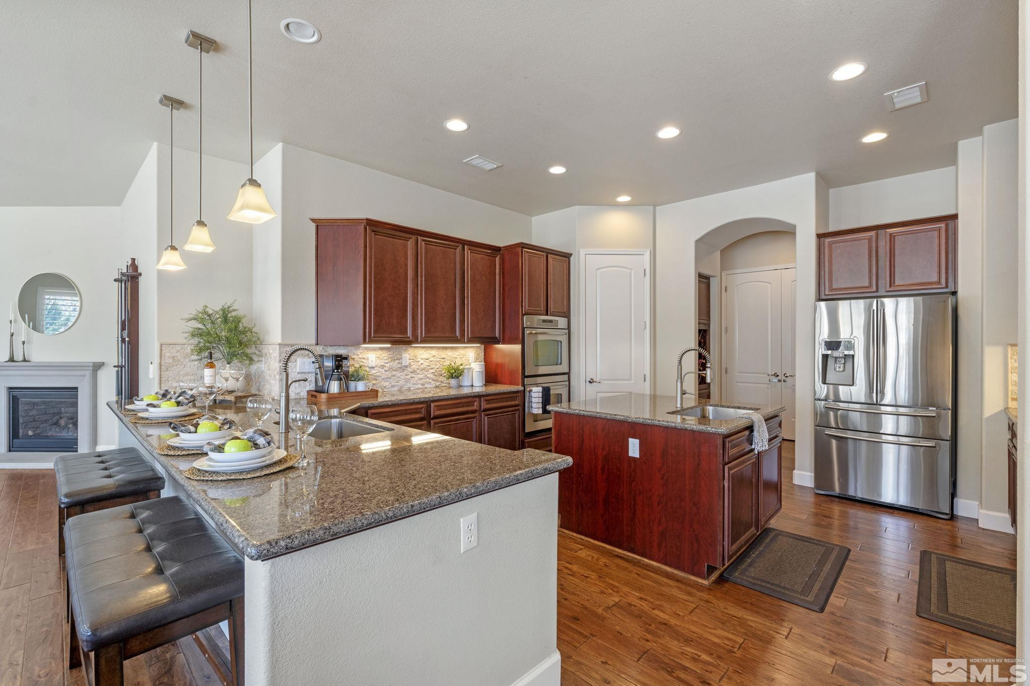 12265 Hidden Sparks, NV 89441 - Photo 14 of 39 a kitchen with a refrigerator a sink dishwasher and wooden cabinets with wooden floor