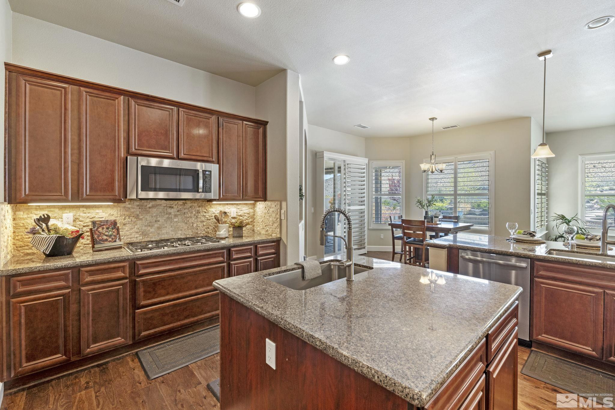 12265 Hidden Sparks, NV 89441 - Photo 15 of 39 a kitchen with stainless steel appliances granite countertop a sink a microwave and wooden cabinets