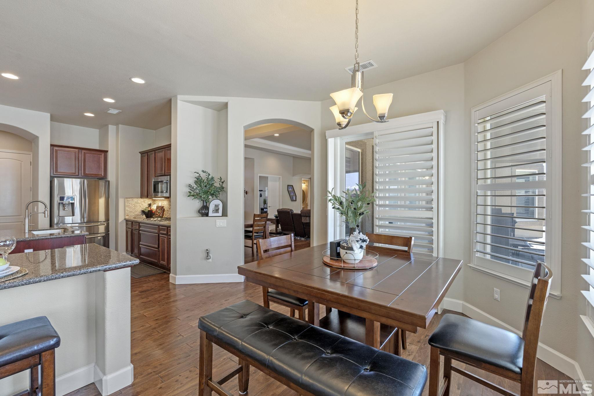 12265 Hidden Sparks, NV 89441 - Photo 18 of 39 a view of a dining room with furniture a chandelier and wooden floor