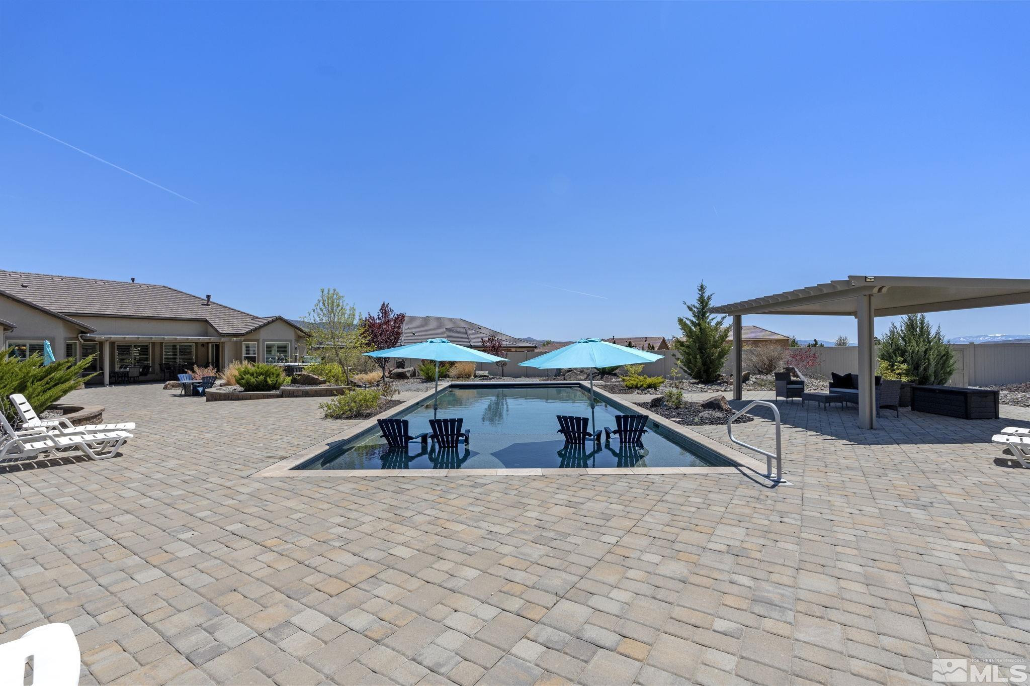 12265 Hidden Sparks, NV 89441 - Photo 31 of 39 a roof deck with table and chairs under an umbrella