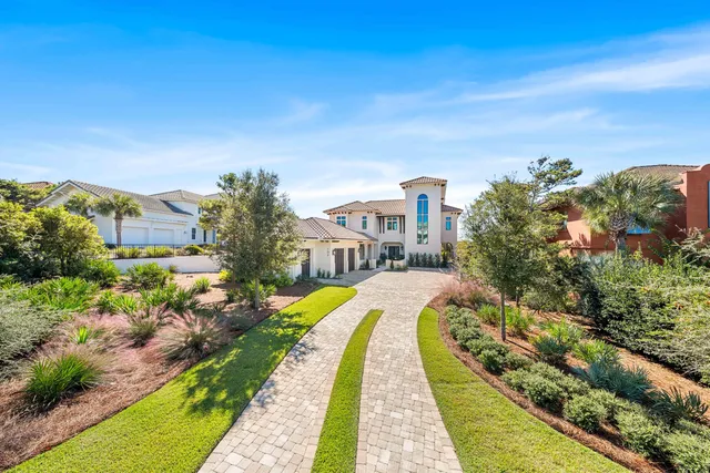 a bathroom with a granite countertop toilet a sink a mirror a window and a shower