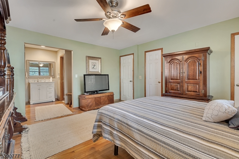 279 Madison Hill Road Clark, NJ 07066 - Photo 14 of 35 a bedroom with a bed and a large mirror with wooden floor