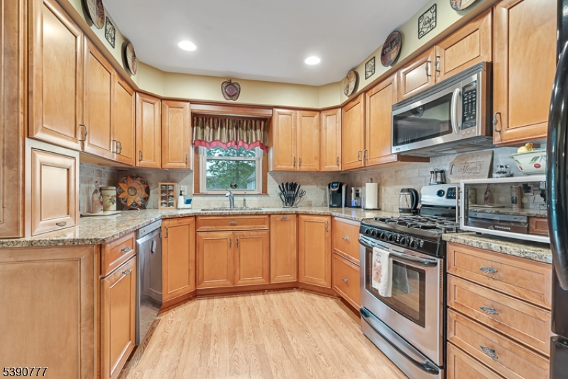 279 Madison Hill Road Clark, NJ 07066 - Photo 8 of 35 a kitchen with stainless steel appliances granite countertop a stove a sink and a microwave
