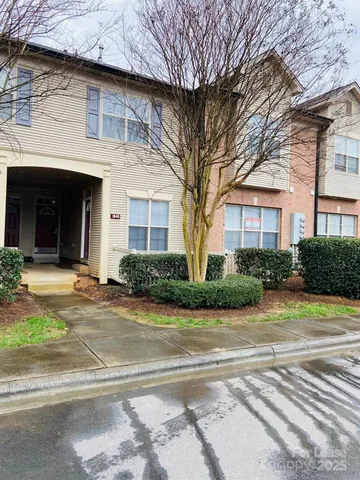 a front view of a house with garden and plants
