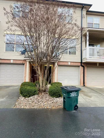 a front view of a house with garage and parking