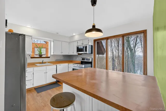 a kitchen with stainless steel appliances granite countertop a sink a stove and a refrigerator