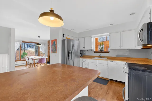 a kitchen with stainless steel appliances granite countertop a sink and a refrigerator