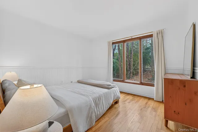 a bedroom with a bed and a large window