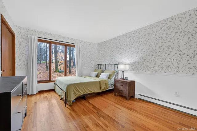 a spacious bedroom with a bed and wooden floor