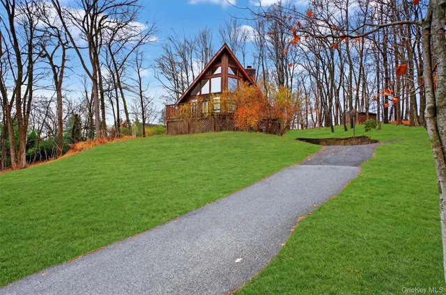 a front view of a house with a yard and trees
