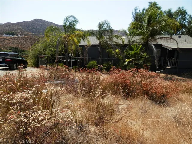 a view of a house with a yard and a car park in front of it