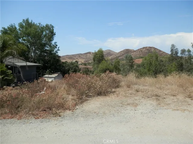 a view of a dry yard with wooden fence