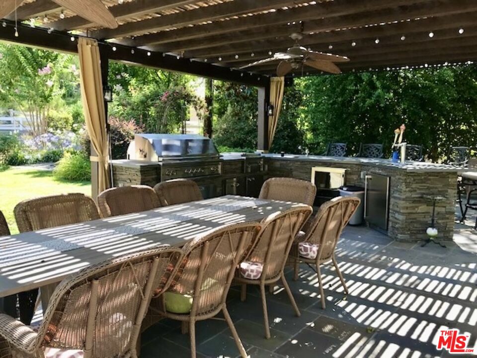 24024 Long Valley Road Hidden Hills, CA 91302 - Photo 5 of 6 a view of a patio with a table chairs and a wooden floor