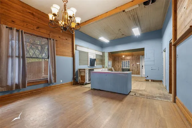 a view of a kitchen with a fridge and wooden floor