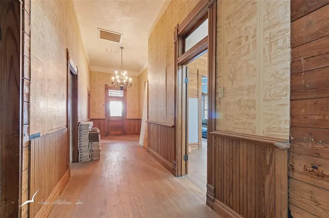 a view of a hallway with wooden floor and staircase