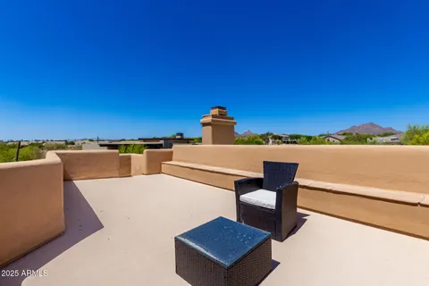 a view of roof deck with a table and chairs