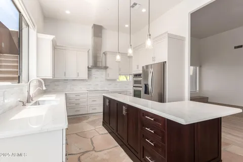 a kitchen with a sink a counter top space stainless steel appliances and cabinets