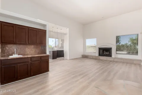 a kitchen with granite countertop a stove top oven a sink dishwasher and a fireplace with wooden floor