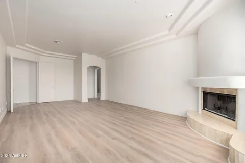 a view of empty room with wooden floor and fireplace