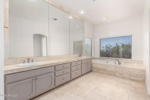 a large bathroom with a large mirror vanity and shower