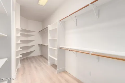 a view of walk in closet with empty racks