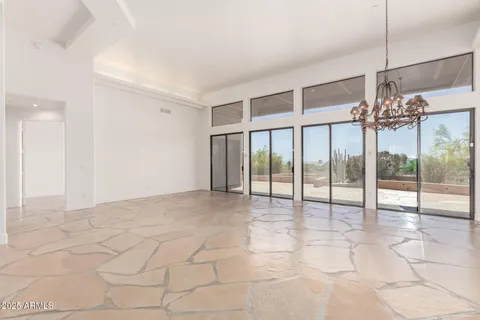 a view of a livingroom with a floor to ceiling window and an entryway