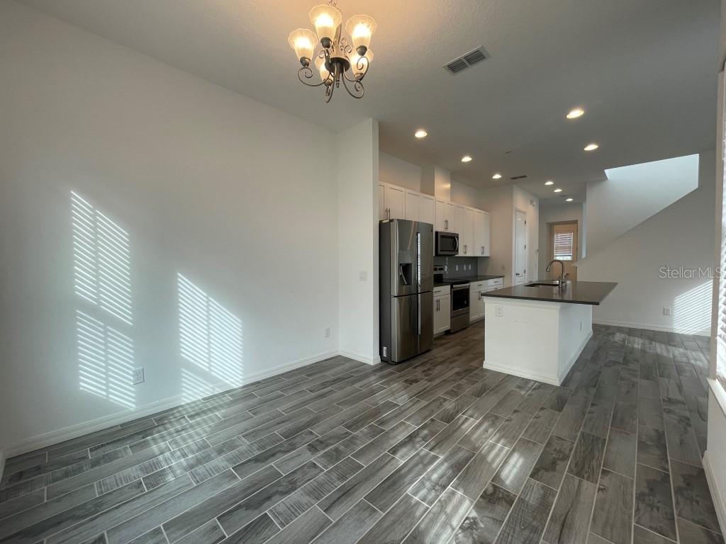 191 Sun Palm Lane Altamonte Springs, FL 32701 - Photo 5 of 16 a view of a kitchen with stainless steel appliances granite countertop a refrigerator a stove and a wooden floors