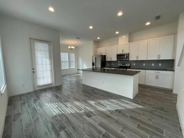 a view of kitchen with granite countertop cabinets and wooden floor