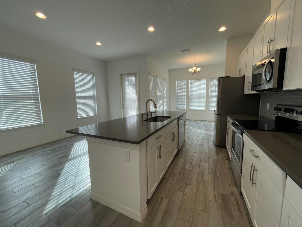 191 Sun Palm Lane Altamonte Springs, FL 32701 - Photo 7 of 16 a kitchen with stainless steel appliances granite countertop a sink a stove and a wooden floors
