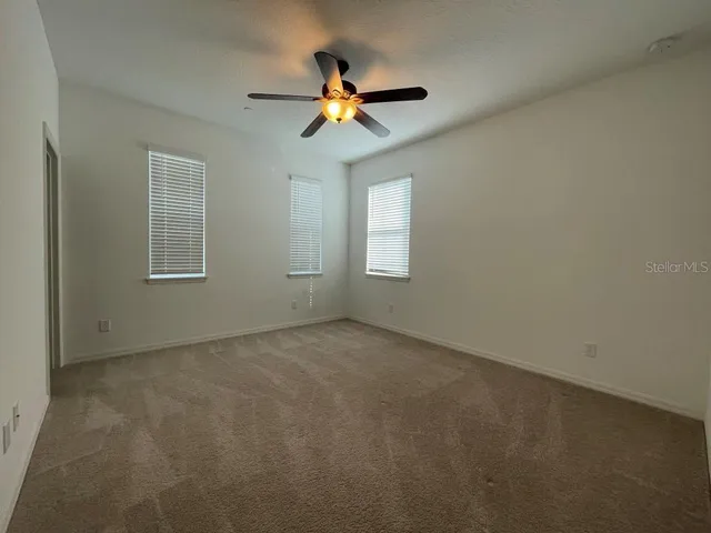 a view of a livingroom with a ceiling fan and window