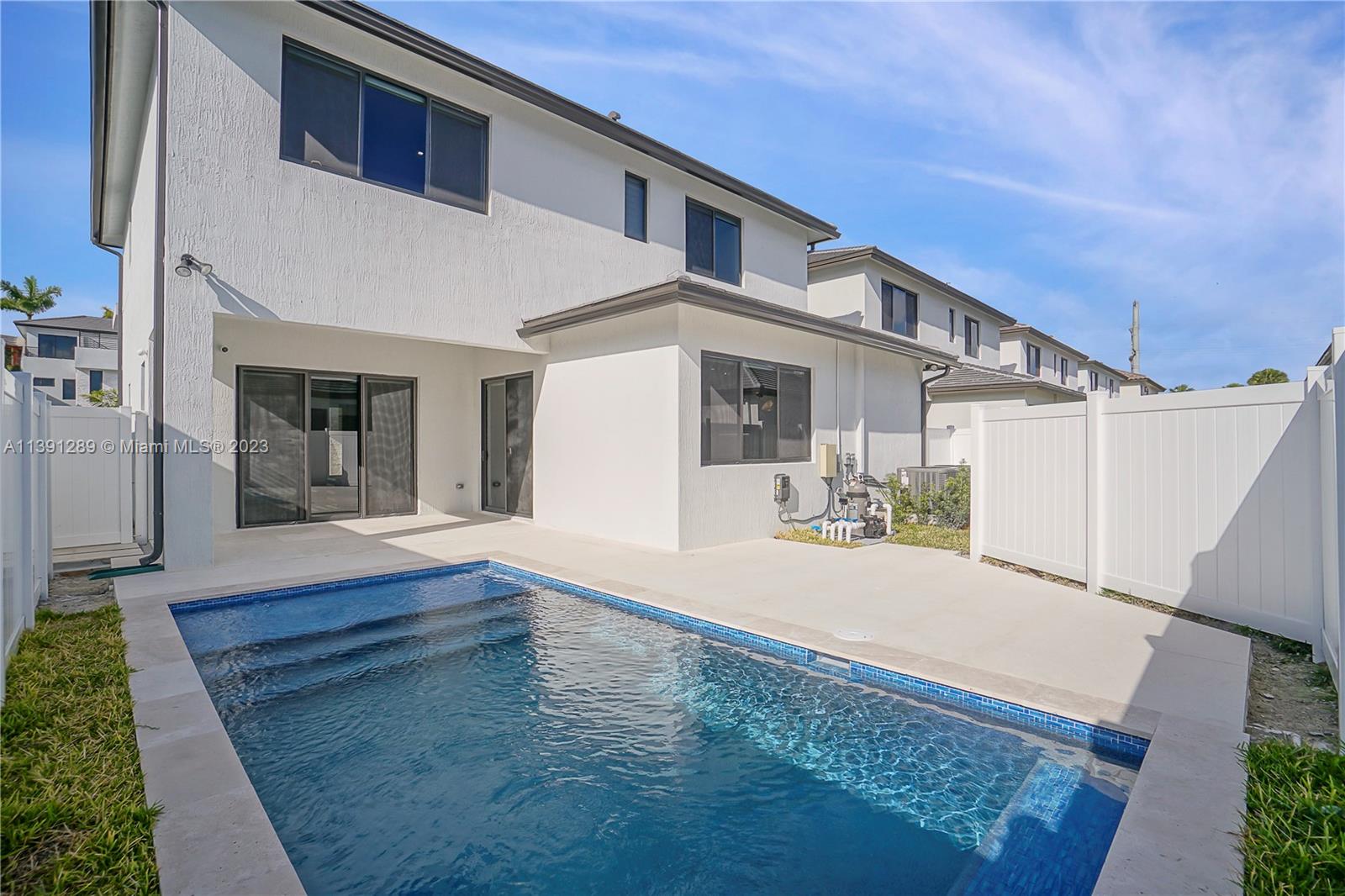 a view of backyard of house and wooden deck