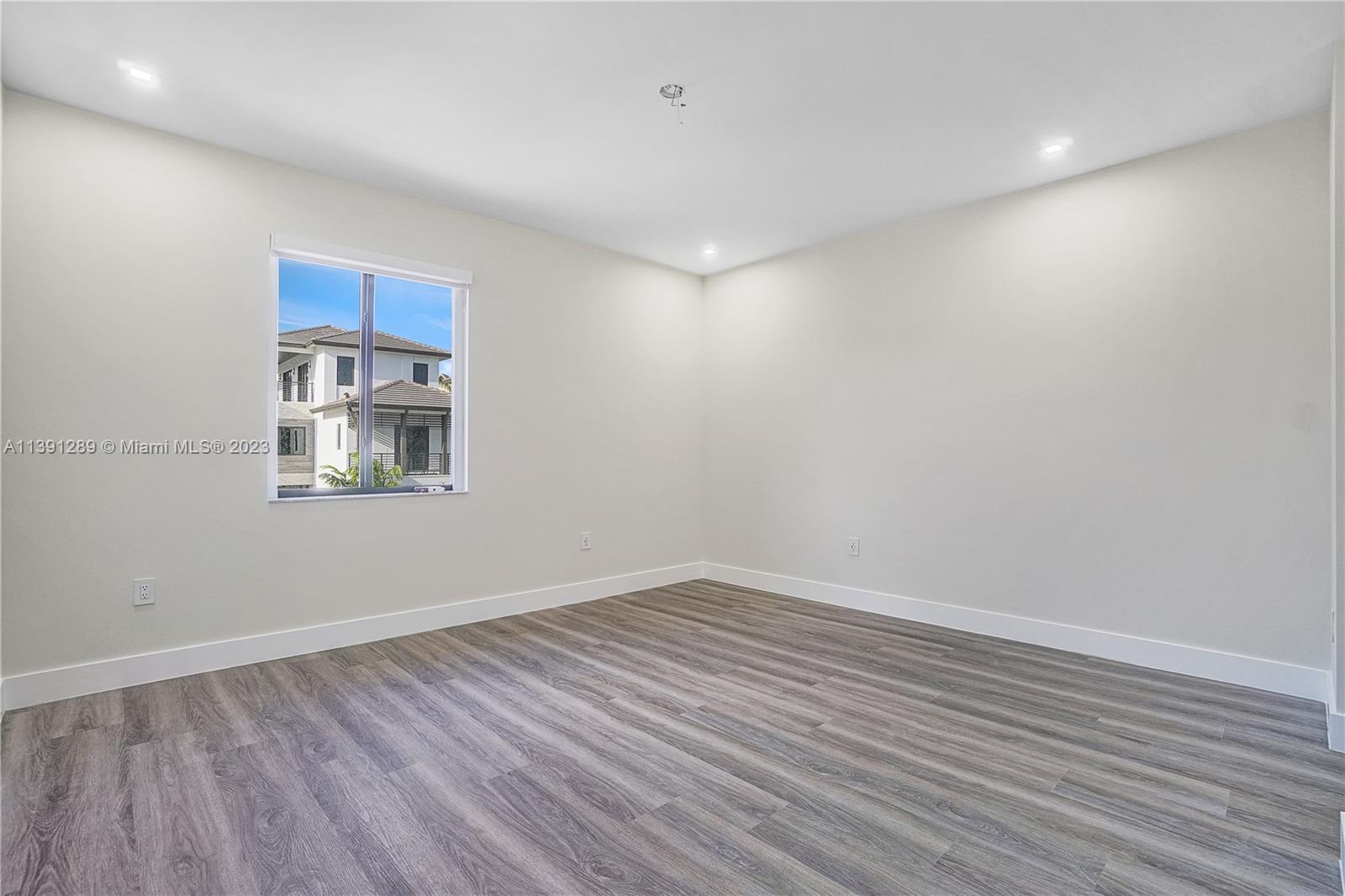 8096 Northwest 48th Terrace Doral, FL 33166 - Photo 12 of 28 a room with a wooden floor and white walls