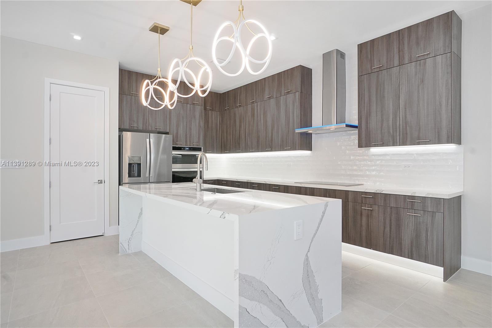 8096 Northwest 48th Terrace Doral, FL 33166 - Photo 20 of 28 a kitchen with stainless steel appliances granite countertop a sink a stove and a refrigerator