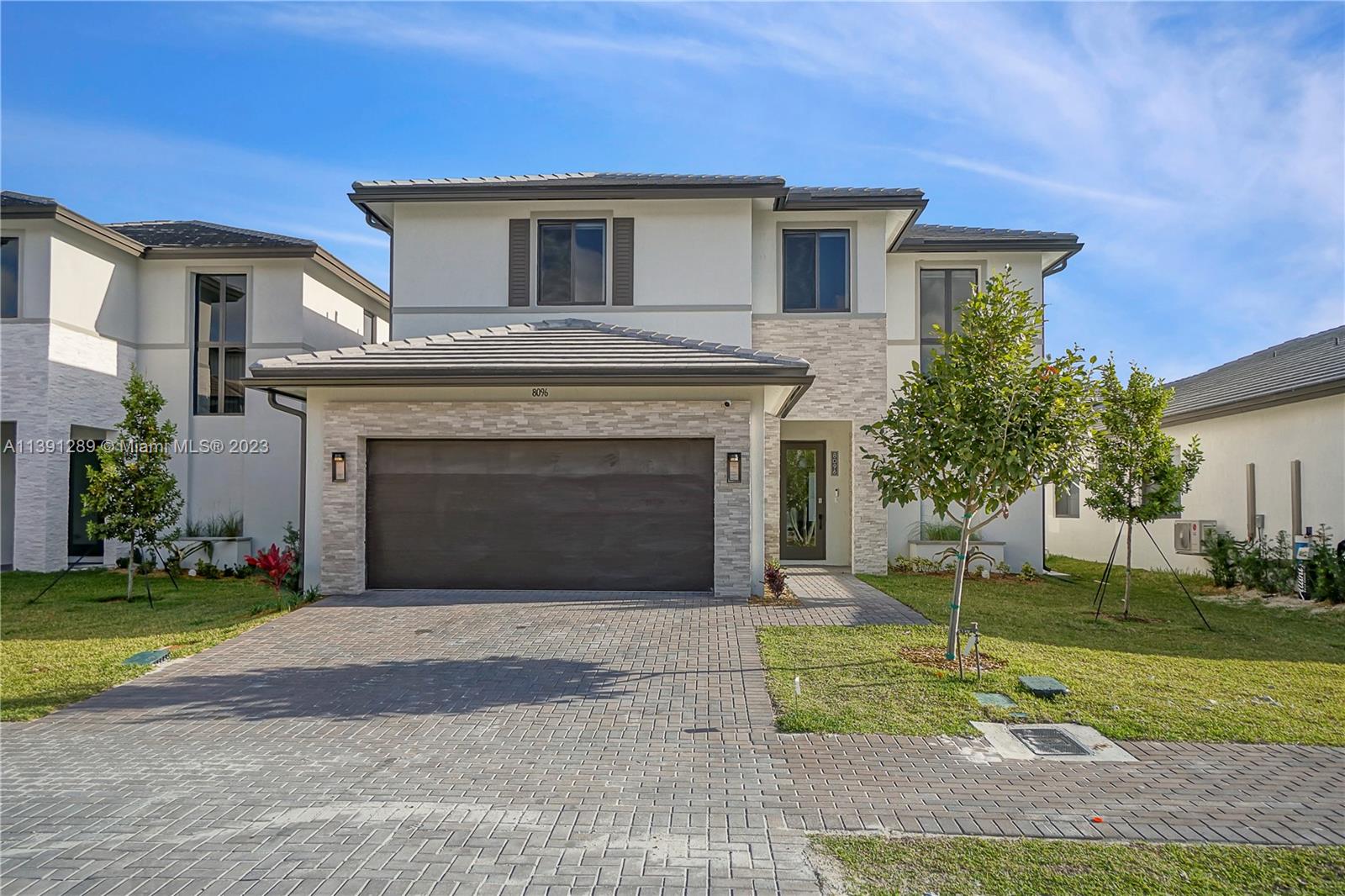 8096 Northwest 48th Terrace Doral, FL 33166 - Photo 25 of 28 a front view of a house with a yard and garage