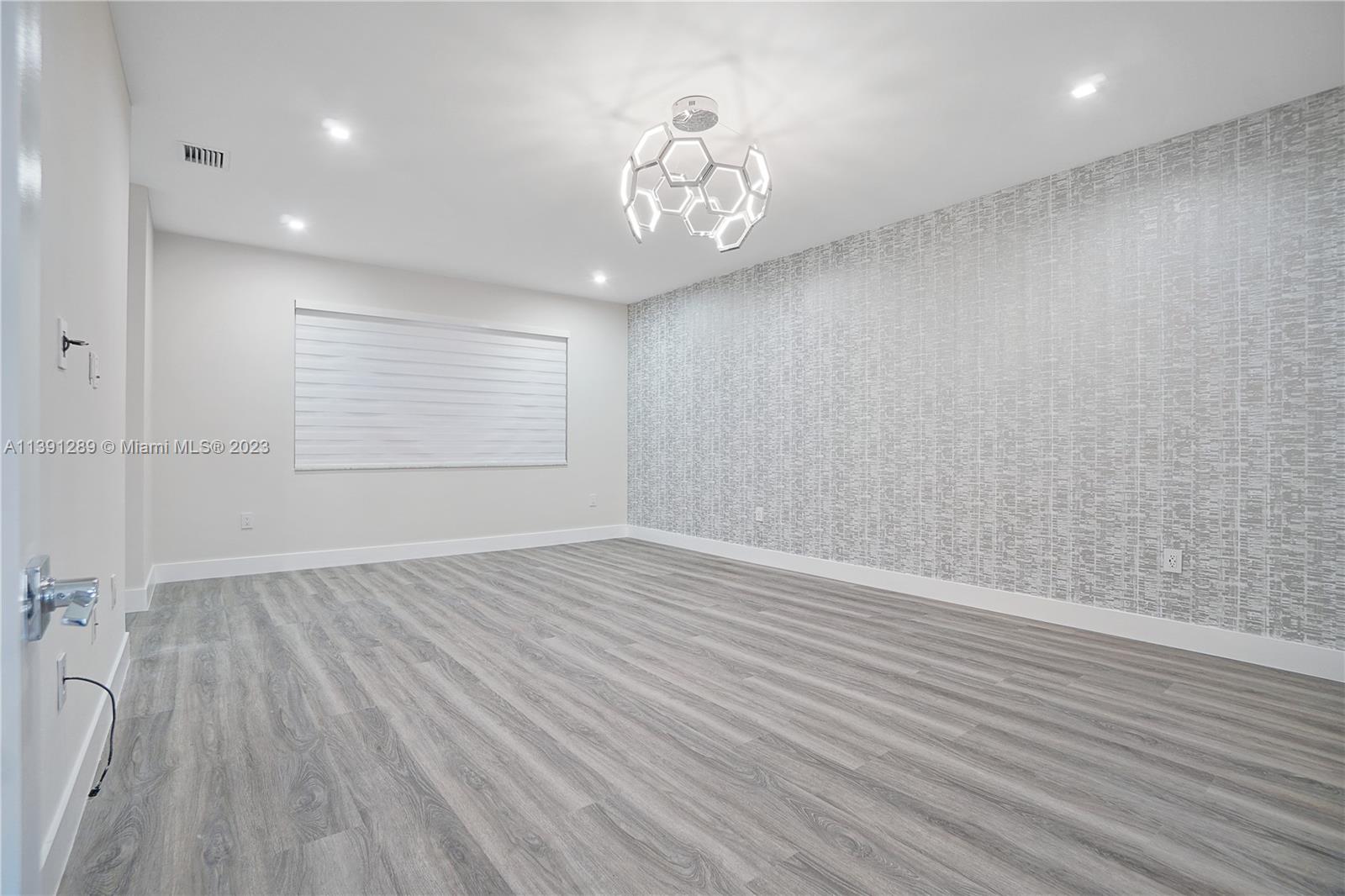 8096 Northwest 48th Terrace Doral, FL 33166 - Photo 6 of 28 an empty room with wooden floor and windows