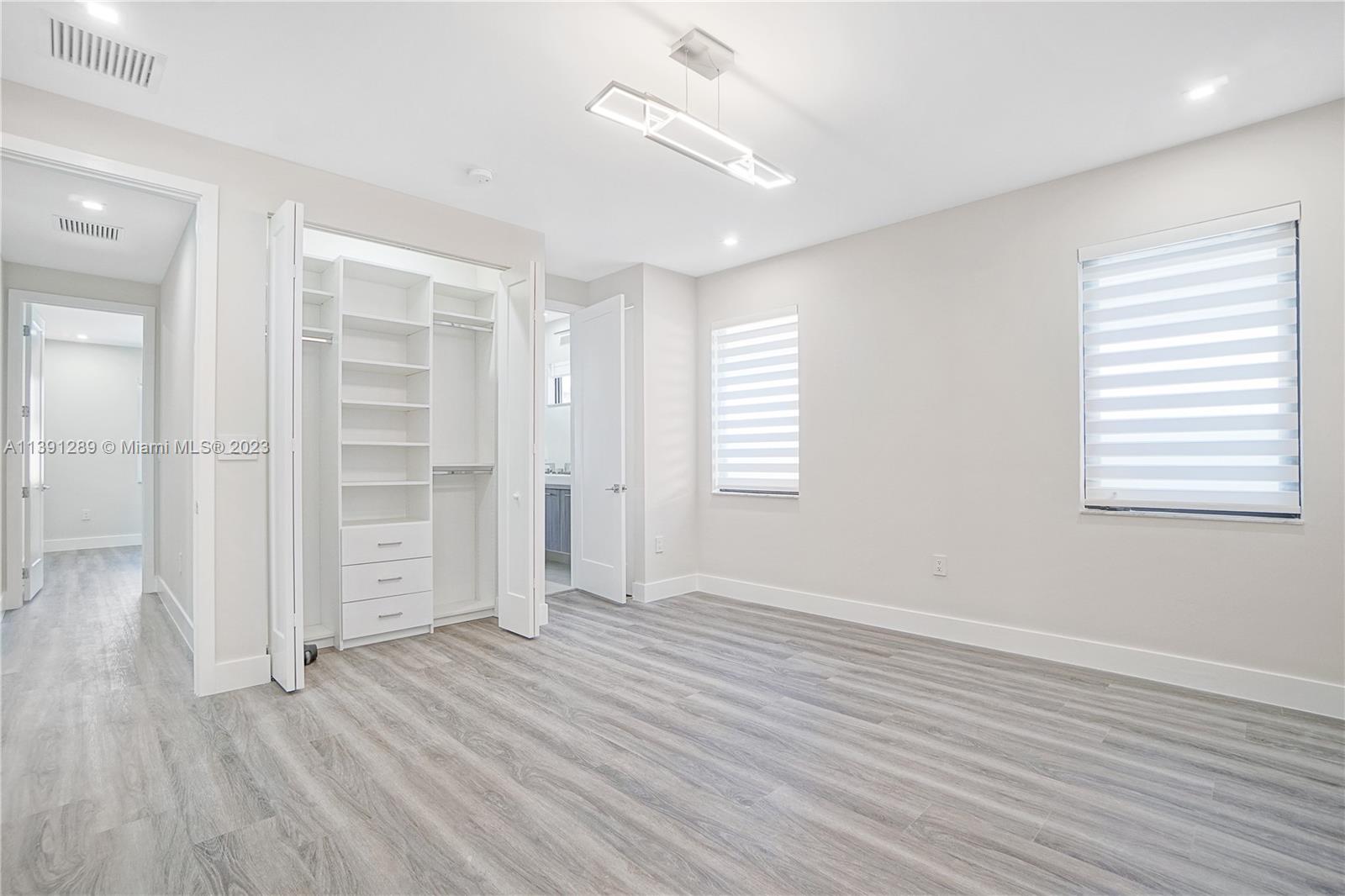 8096 Northwest 48th Terrace Doral, FL 33166 - Photo 9 of 28 an empty room with wooden floor closet and windows