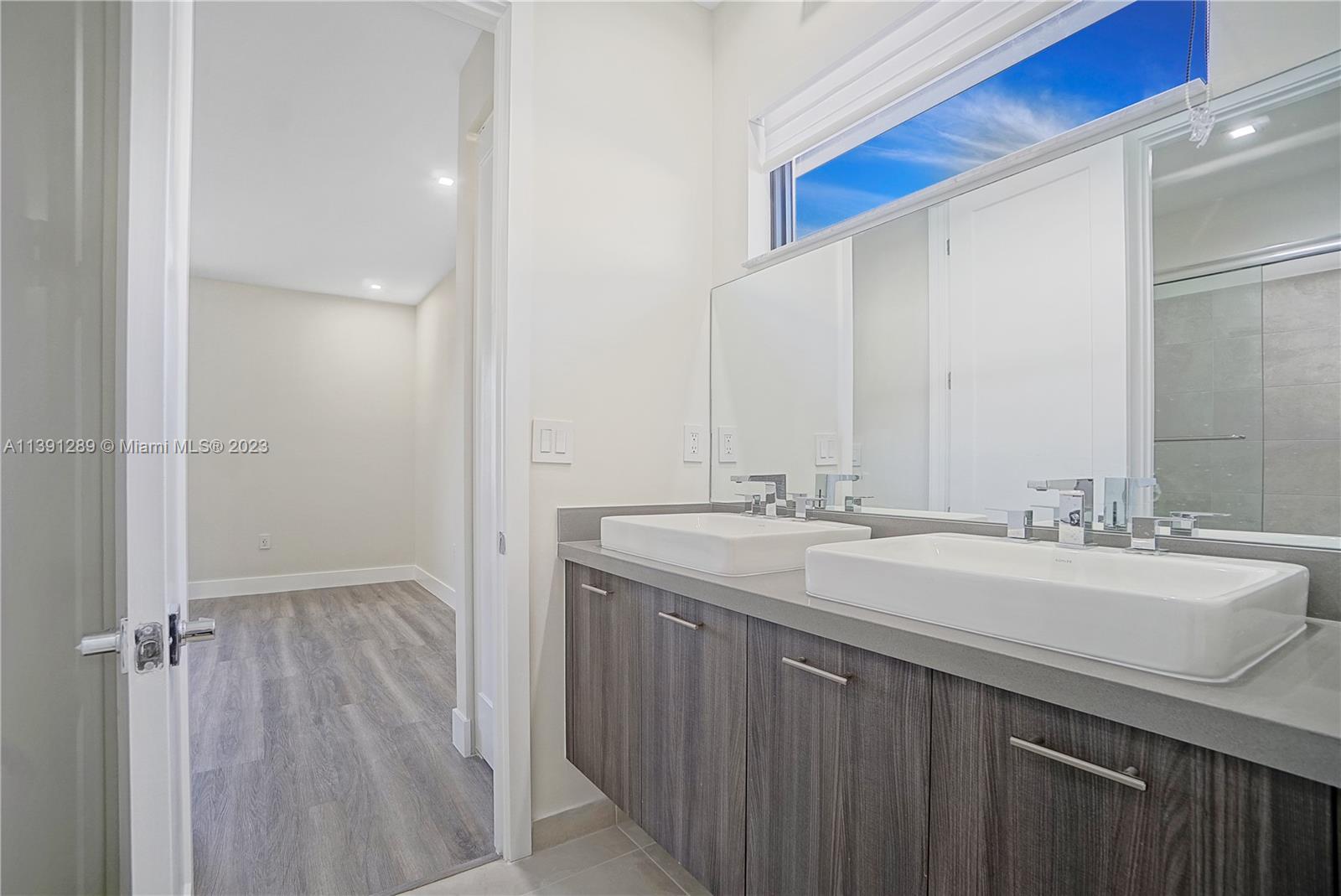 8096 Northwest 48th Terrace Doral, FL 33166 - Photo 10 of 28 a bathroom with a double vanity sink and mirror