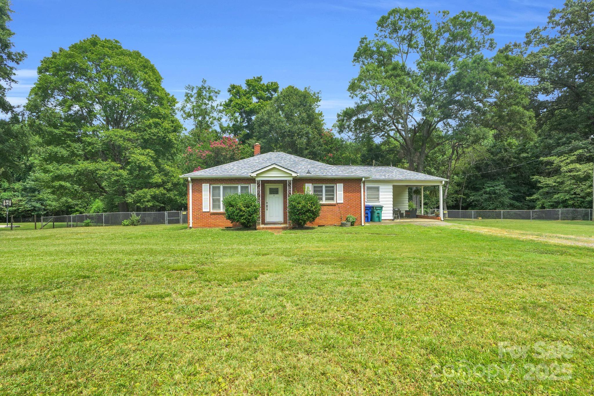 10437 Idlewild Road Matthews, NC 28105 - Photo 2 of 12 a front view of a house with a garden