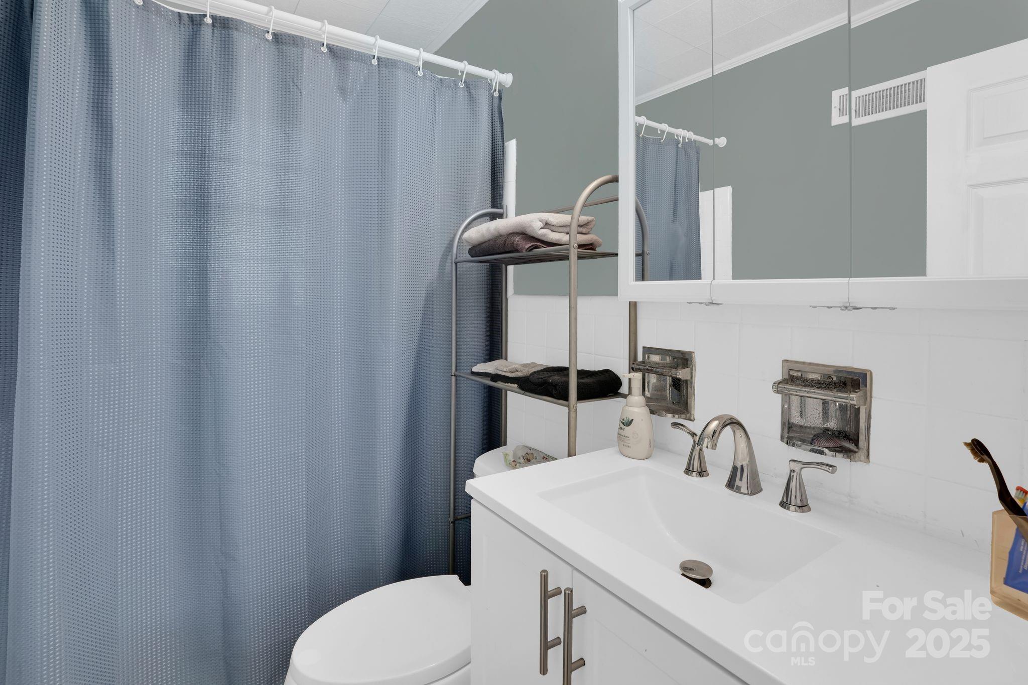 10437 Idlewild Road Matthews, NC 28105 - Photo 10 of 12 a bathroom with a sink a toilet and mirror