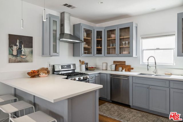 a kitchen with stainless steel appliances granite countertop a sink stove cabinets and a refrigerator