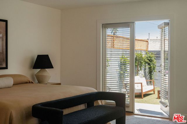 a bedroom with a bed and a lamp on dresser