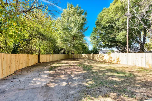 a view of yard with tree and wooden fence