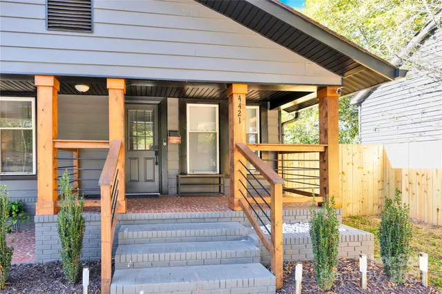 a porch with a table and chairs next to a yard