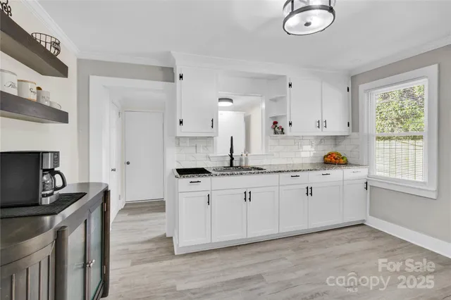 a kitchen with granite countertop a sink cabinets and window
