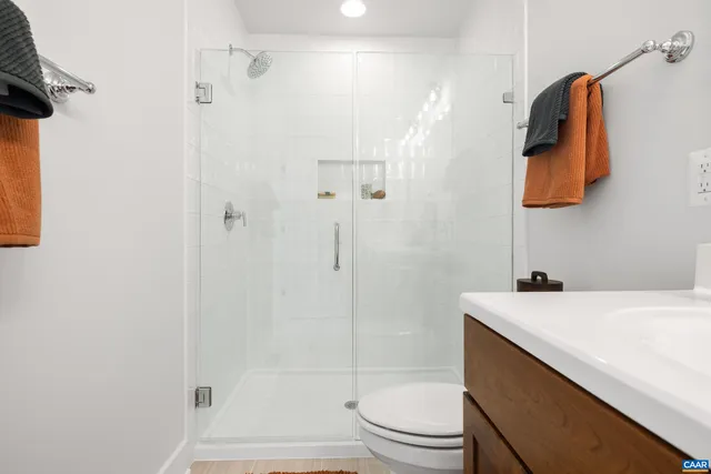 a bathroom with a sink a toilet and shower