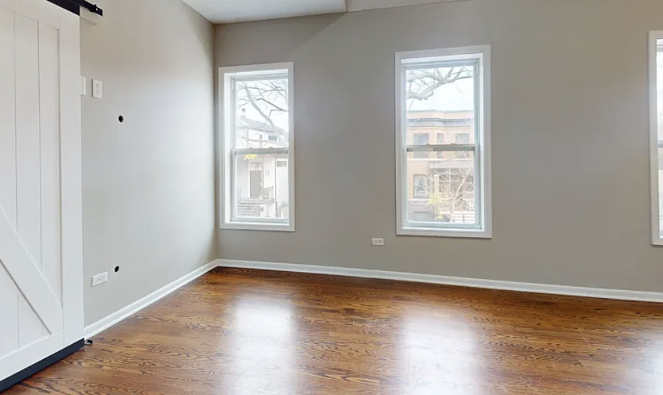 2101 West Fletcher Street, Unit 2F Chicago, IL 60618 - Photo 6 of 8 a view of an empty room with wooden floor and a window