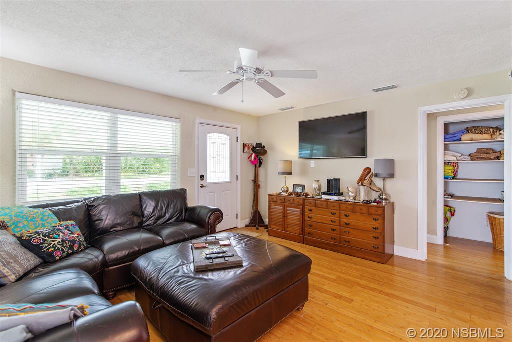 405 Tide Street New Smyrna Beach, FL 32169 - Photo 2 of 33 a living room with furniture and a flat screen tv