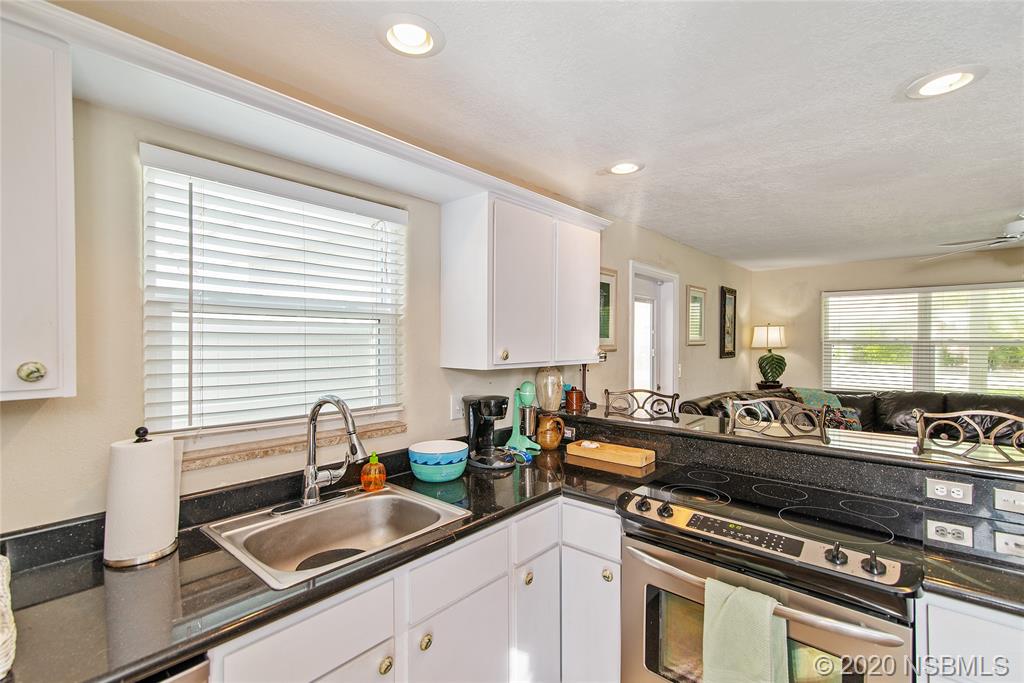 405 Tide Street New Smyrna Beach, FL 32169 - Photo 11 of 33 a kitchen with a sink and a stove