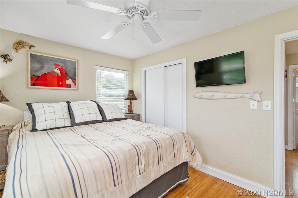 405 Tide Street New Smyrna Beach, FL 32169 - Photo 14 of 33 a bedroom with a bed and a flat screen tv