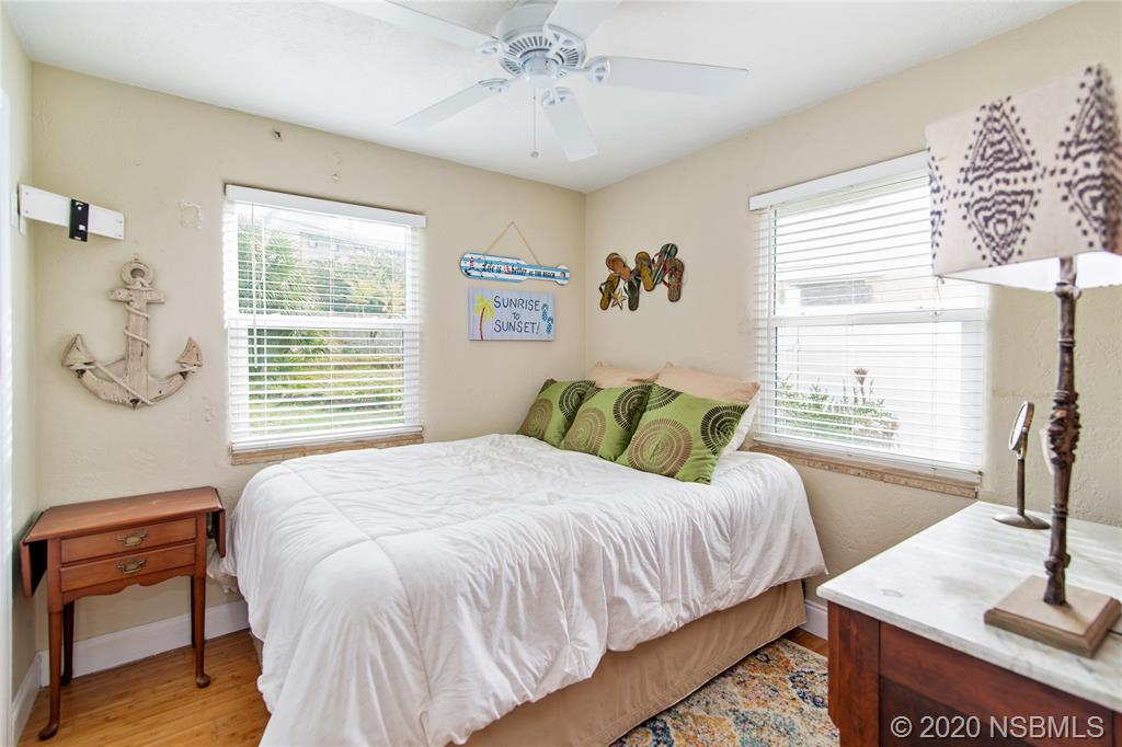 405 Tide Street New Smyrna Beach, FL 32169 - Photo 16 of 33 a bedroom with a bed and a table with chair